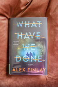 what have we done by alex finlay laying on brown pillow