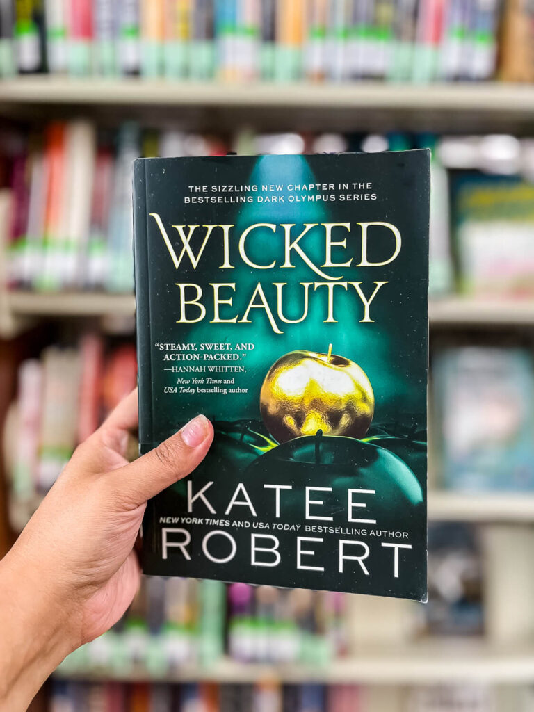 woman's hand holding Wicked Beauty book by Katee Robert