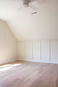 white walls with light wood floors and wood accent wall