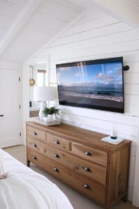 wood dresser and wall mounted TV in a bedroom