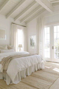 all white bedroom with white linens and sheer curtains